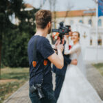 A shallow focus shot of a wedding photographer takes pictures of the bride and groom